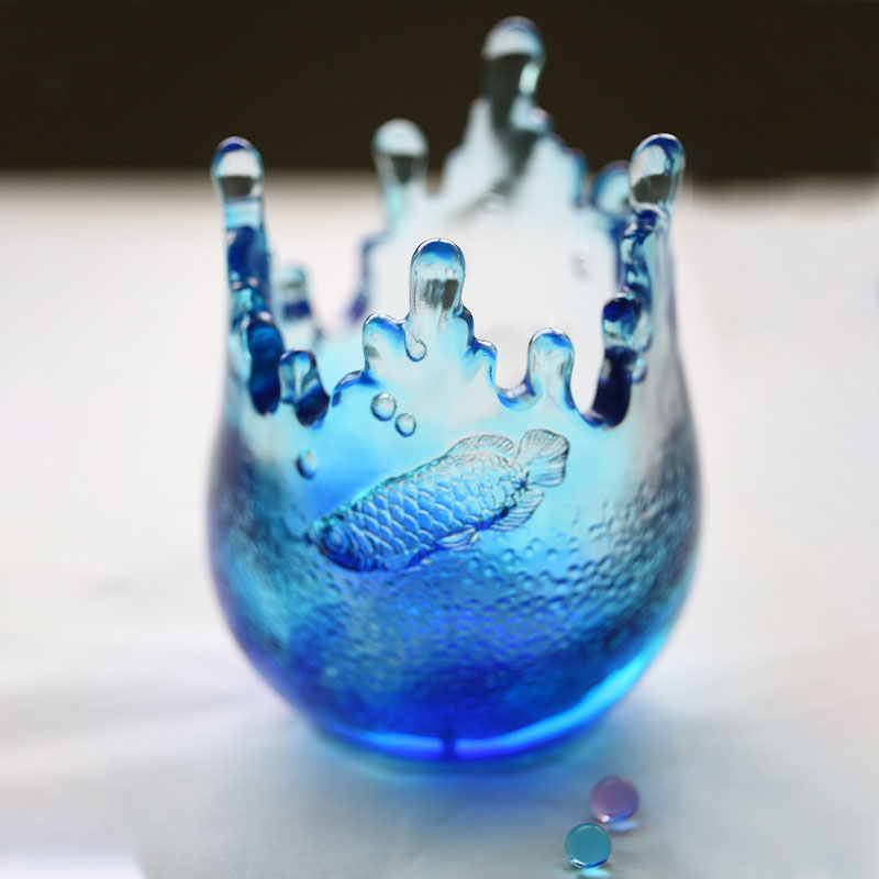 Blå ornamenter i glass gravert med fiskemønstre