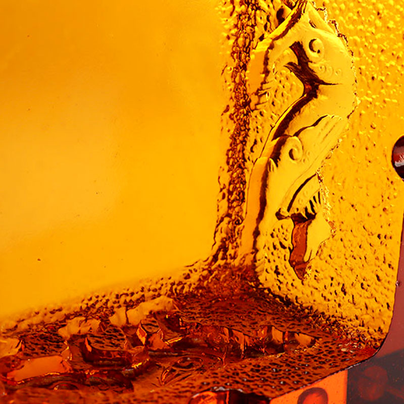 Rødt glassaskebeger med utsøkte pregede dyremønstre