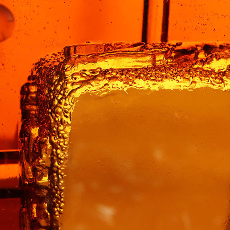 Rødt glassaskebeger med utsøkte pregede dyremønstre