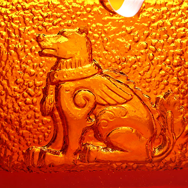 Rødt glassaskebeger med utsøkte pregede dyremønstre