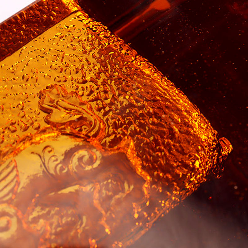 Rødt glassaskebeger med utsøkte pregede dyremønstre