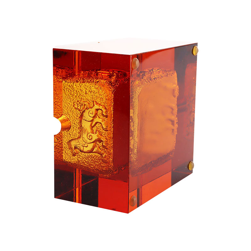 Rødt glassaskebeger med utsøkte pregede dyremønstre