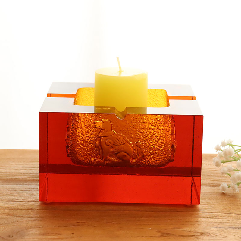 Rødt glassaskebeger med utsøkte pregede dyremønstre